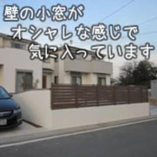 木の質感のあるアルミフェンスと、小窓のある塗り壁