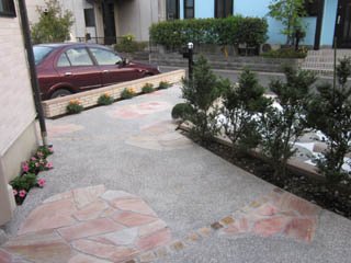 アプローチにも植栽スペースを設け、床面は乱形石貼りを洗い出し舗装とのコラボでデザインしました。